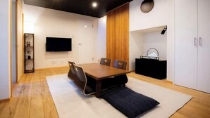 A modern dining area with a wooden table, four chairs, and a black console table. - Kyoya Nobuhiro Reisen (Kyoto)