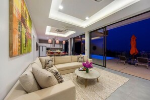 Una sala de estar moderna con un sofá modular, una mesa de centro y vistas al área exterior.