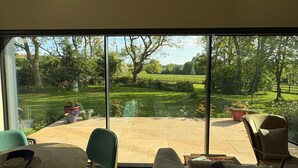 Ein modernes Wohnzimmer mit einem großen Glasschiebetür zu einem Garten.
