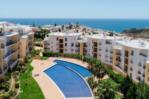 A residential building with a swimming pool, balconies, and a view of the sea. - BnB Homes Ocean View Apartment with relax Terrace, 2 Swimming pools & Tennis court (Albufeira)