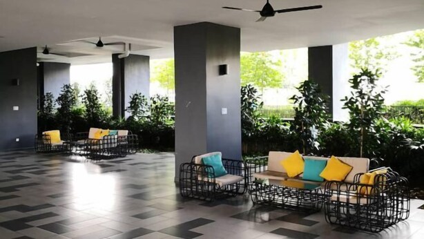 An indoor seating area with chairs and sofas, ceiling fans, and large windows with greenery outside. - D'sands Residences Midvalley (Kuala Lumpur)