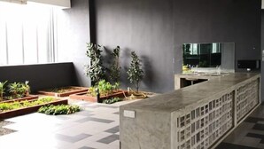 A modern indoor space with a long counter, potted plants, and a large mirror. - D'sands Residences Midvalley (Kuala Lumpur)