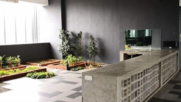A modern indoor space with a long counter, potted plants, and a large mirror. - D'sands Residences Midvalley (Kuala Lumpur)