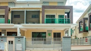 A modern two-story residential building with a balcony, large windows, and a gated entrance. - Tropical Livings Meru Ipoh Homestay (Ipoh)