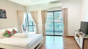 A bedroom with a bed, curtains, a TV, and a window with blinds. - Tropical Livings Meru Ipoh Homestay (Ipoh)