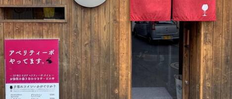A wooden exterior with a sign reading 'lievre' and a red curtain with a wine glass symbol.