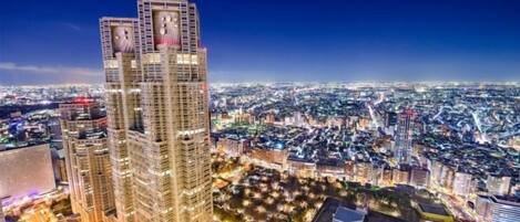 A high-rise building with multiple floors, surrounded by a cityscape at night.