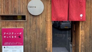 A wooden building entrance with a sign reading 'lievre' and a red curtain. - SunStay Higashinakano (Tokyo)