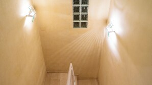 A narrow stairwell with a small window and wall-mounted lights. - Duplex in Gelves with private pool and large terrace, near Seville (Gelves)