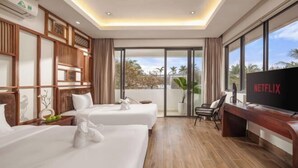 A hotel room with two beds, a TV, and a balcony with a view. - Ocean Villa Da Nang 4BR 5 Beds, Private Pool and Kitchen (Da Nang)