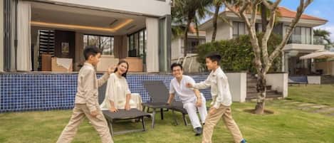 A modern house with a pool, outdoor seating, and a well-maintained lawn.