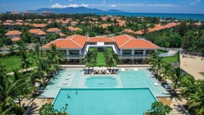 A resort with a central swimming pool, multiple guest villas, and a beach view. - Ocean Villa Da Nang 4BR 5 Beds, Private Pool and Kitchen (Da Nang)