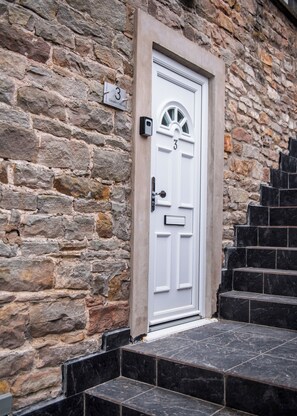 A white door with the number 3, set in a stone wall with a small mailbox above it. - Eden Grove by Guestz (Appleby-in-Westmorland)