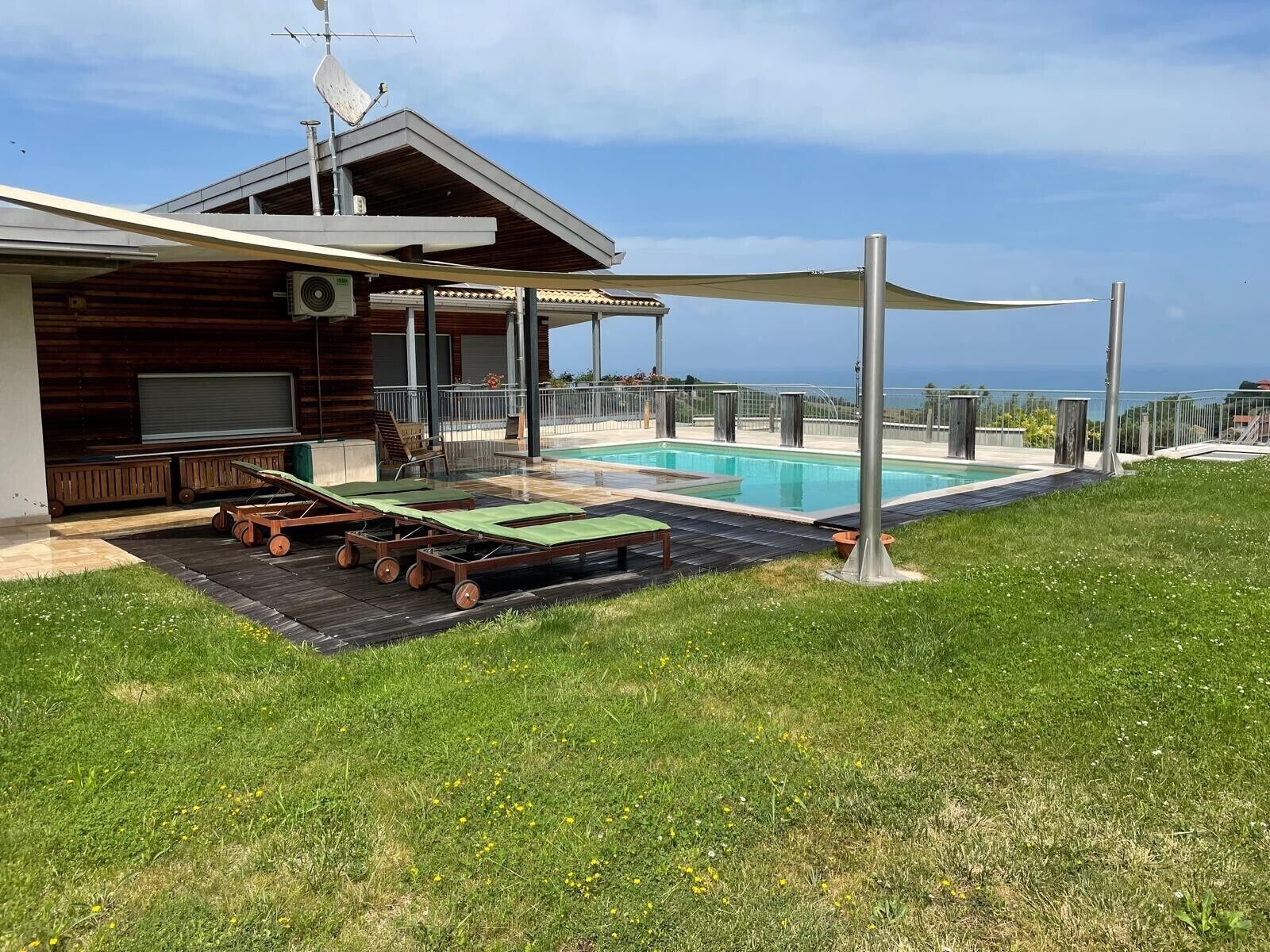 Un edificio moderno con piscina, area relax all'aperto e vista sull'oceano.
