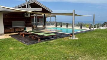 Un edificio moderno con piscina, area relax all'aperto e vista sull'oceano.