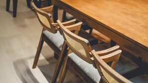 A wooden dining table surrounded by six chairs with woven backs and cushioned seats. - Austin Shoplot Grand KTV Party 15pax Mahjong Chill (Tebrau)