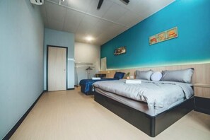 Ein Schlafzimmer mit Bett, Schreibtisch, Stuhl, Kleiderschrank und einer Tür.