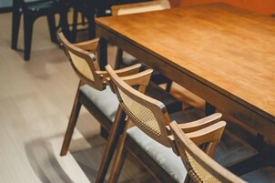 Una mesa de madera para comer con seis sillas, cada una con asiento y respaldo acolchados.