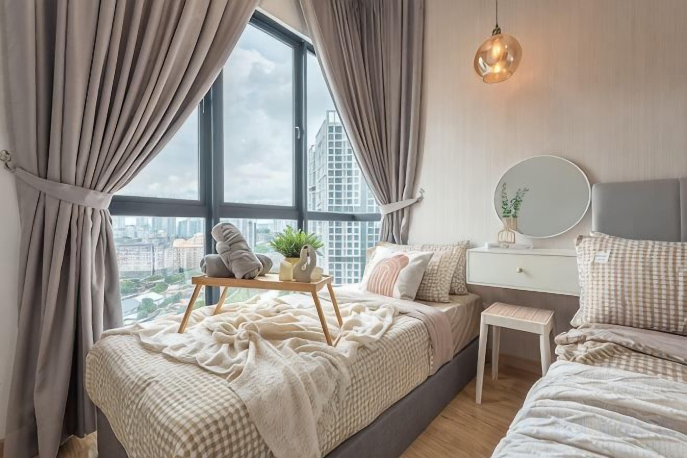 A bedroom with a bed, bedside table, and a window with curtains.