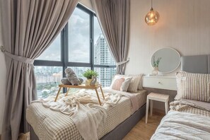Un dormitorio con cama, mesita de noche y ventana con cortinas.