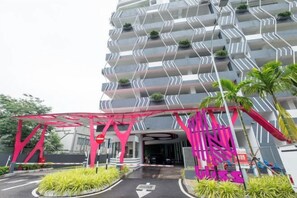 Un hotel de diverses plantes amb una façana característica en forma de zig-zag i una marquesina d'entrada vermella.
