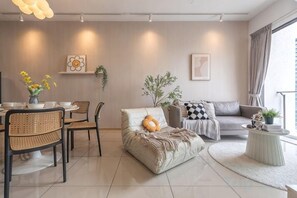 Una sala moderna con sofá, una mesa de centro y un comedor con sillas y una mesa.