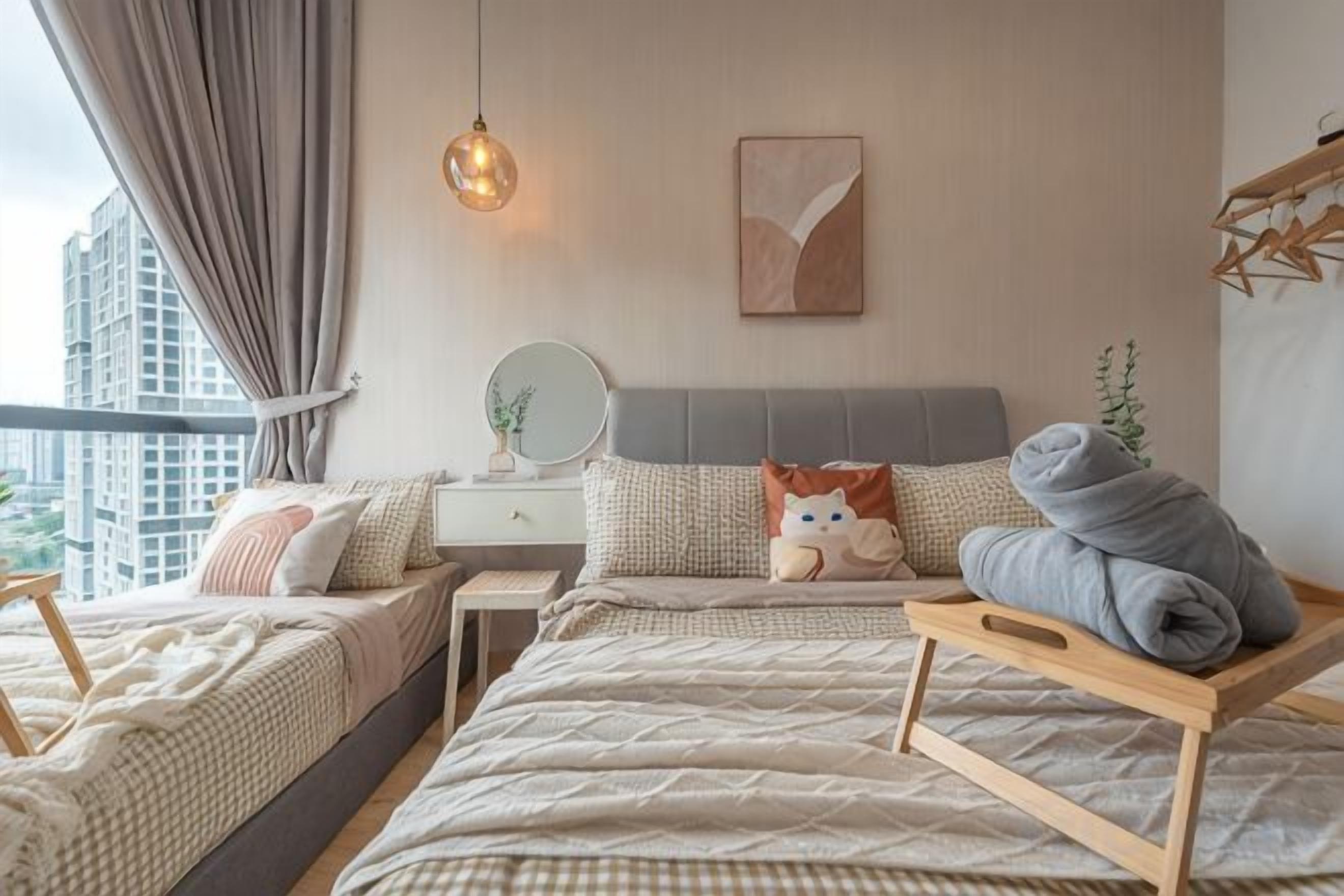 Una camera da letto con un letto, comodini, una lampada a sospensione e vista sulla città.