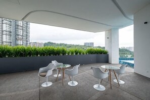 A modern outdoor seating area with a view of the city. - Bliss Residence Old Klang Road by FEEL HOME (Kuala Lumpur)