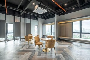 A modern conference room with a large window, a projector, and a herringbone-patterned floor. - Bliss Residence Old Klang Road by FEEL HOME (Kuala Lumpur)