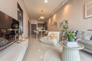 Ein modernes Wohnzimmer mit einer Couch, einem Couchtisch und einem Essbereich mit Stühlen und einem Tisch.