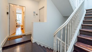 A staircase with white balusters and dark wood steps leading to a landing. - Nomad s Easy Stay - Duque Studio XIX (Porto)