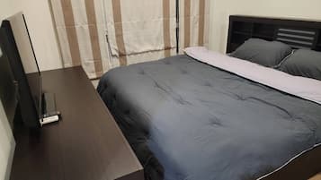 Un dormitorio con cama, escritorio y silla.