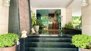 A hotel entrance with a modern design, featuring a staircase, potted plants, and decorative wall sconces. - 14Place Sukhumvit Villa @ Terminal 21 Bangkok (Bangkok)