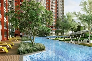 A swimming pool surrounded by greenery and modern buildings.