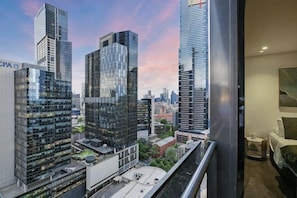 A high-rise building with a modern glass facade, a view of the cityscape, and a balcony with a railing. - A Modern 2BR Apt with City Views, FREE Parking (Southbank)