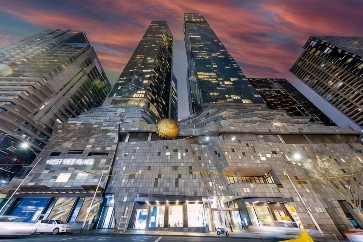 A modern building with a unique facade, multiple floors, and a prominent spherical structure in the center.