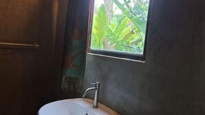A bathroom with a window, a sink, and a towel rack. - Num Homestay (Mae Tha)