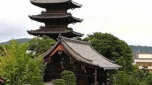 A traditional Japanese pagoda with multiple tiers, surrounded by lush greenery. - KIRAKU・ENRINON (Kyoto)