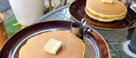 Zwei Pfannkuchen mit Butter auf einem Tisch.
