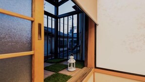 A view through a window with a wooden frame and a white lantern on a small platform. - KIRAKU・ENRINON (Kyoto)
