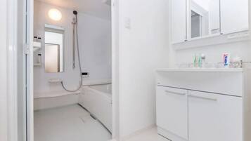 A modern bathroom with a white sink, mirror, and shower.