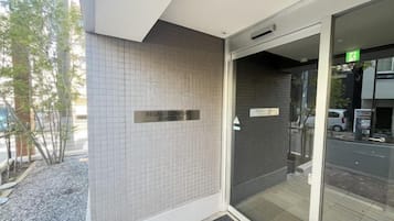 A hotel entrance with a tiled wall, a glass door, and a sign indicating the name 'Regno Confort Hotel'.