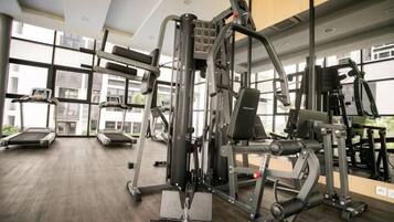 A gym with various exercise machines, treadmills, and a weight bench.
