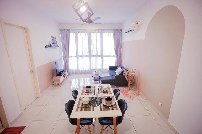 A dining area with a table, chairs, and a TV in the background.