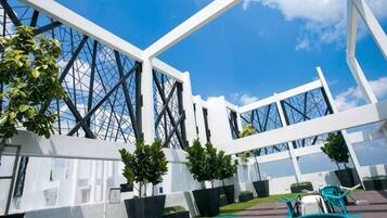 A modern building with a glass facade and white structural elements.