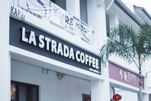 A building with a sign for 'LA STRADA COFFEE' and another sign for 'RESTAURANT.' - Econest Apartment By The One - Educity Ecobotanic (Gelang Patah)