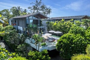 A modern house with a pool, surrounded by lush greenery and palm trees. - Sava Villa 7 Villa Aqua (Takua Thung)
