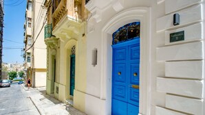 Vista de la calle con una puerta azul, una verde y una blanca.