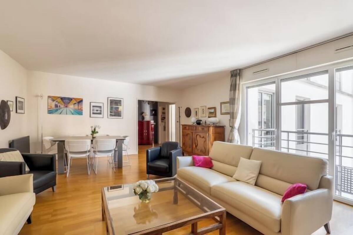 A spacious living room with a sofa, coffee table, and dining area.