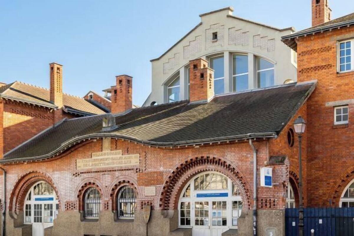 A brick building with arched windows and a flat roof.
